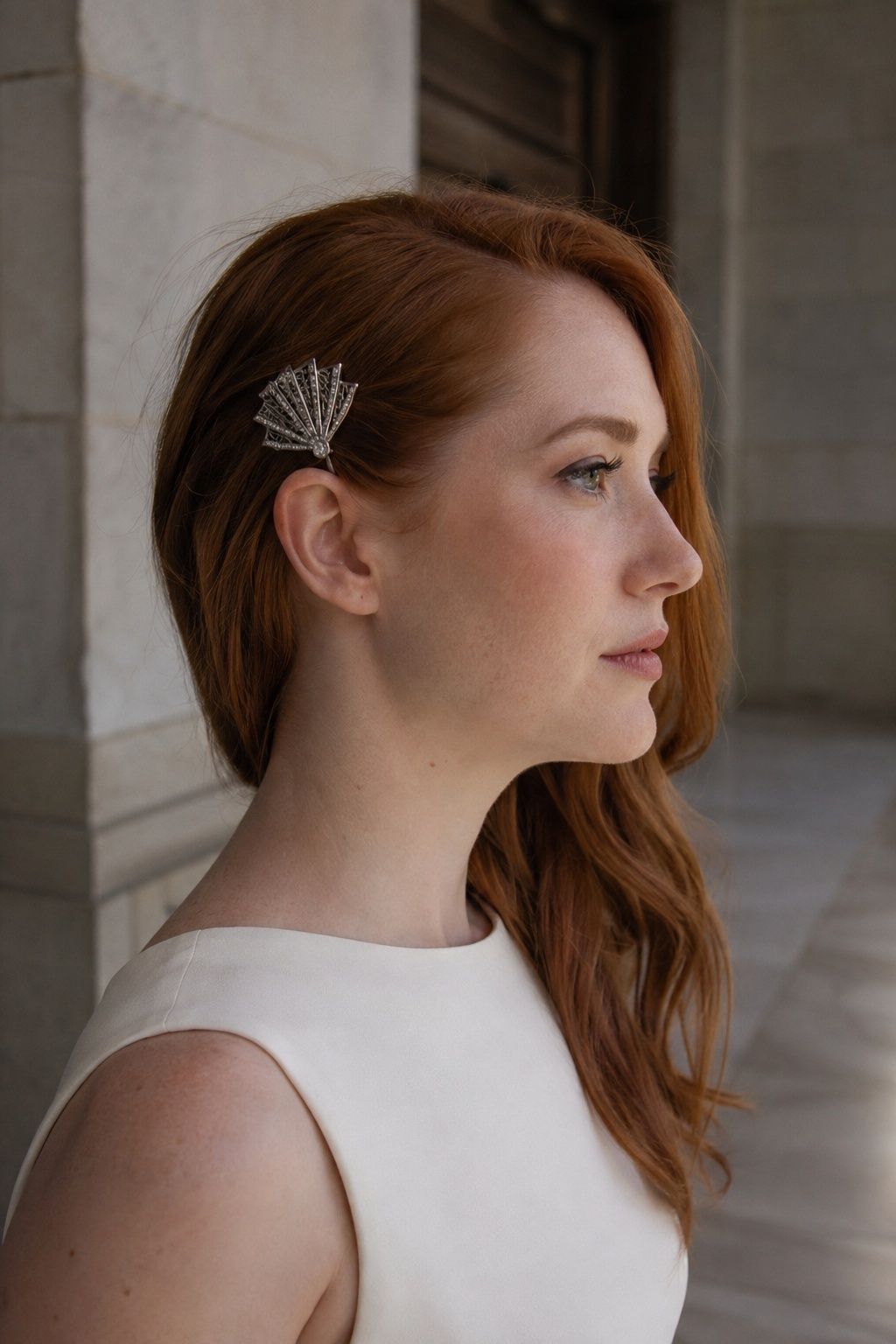 A silver fan-shaped Art Deco comb accents auburn bridal hair.