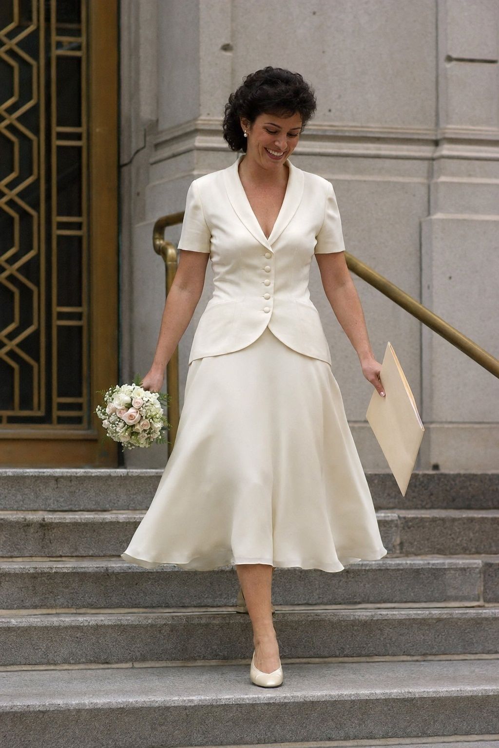 Courthouse bride in a tea-length 1990s ivory jacket wedding dress walking down city hall steps