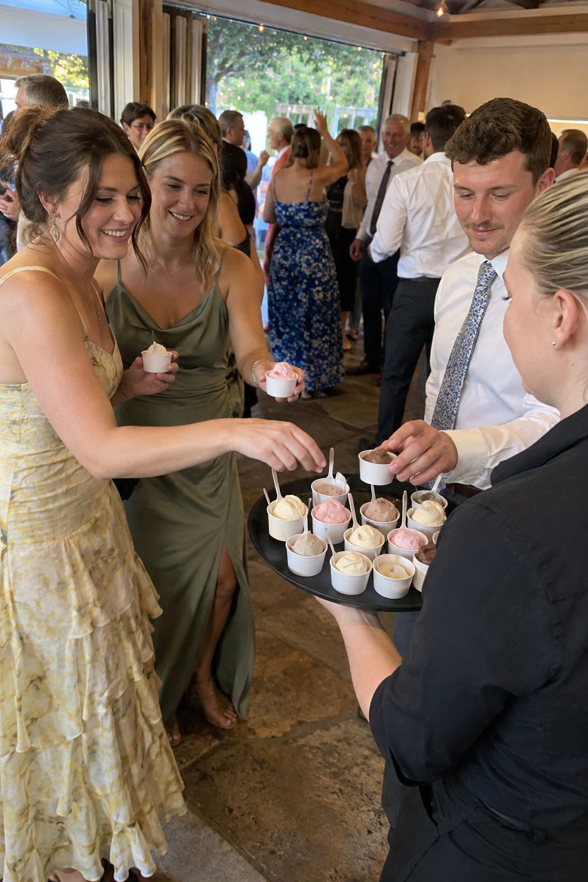 A server passes gelato cups to guests before the dance floor opens at an August wedding.