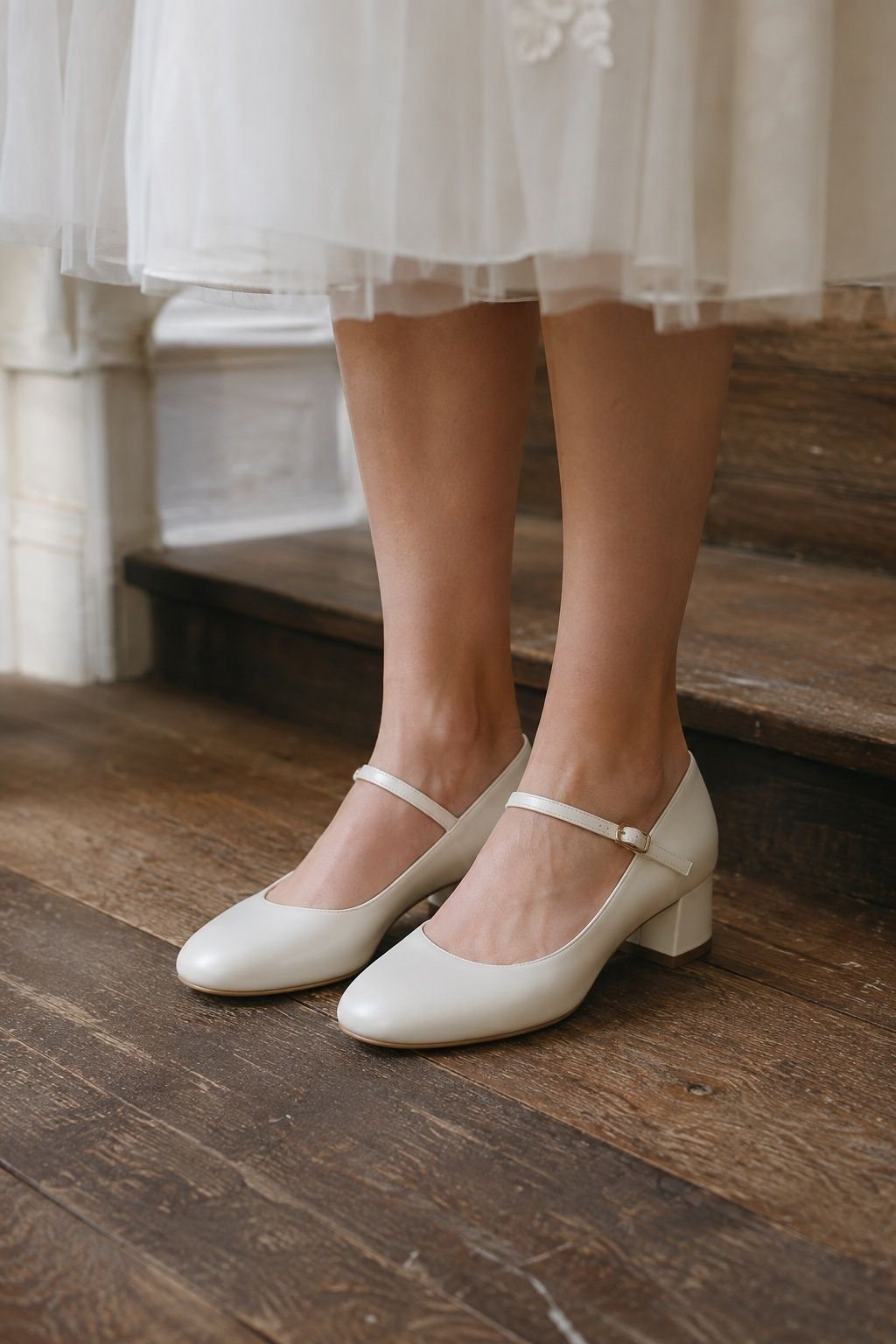 White Mary Jane bridal heels with secure instep straps on wooden stairs