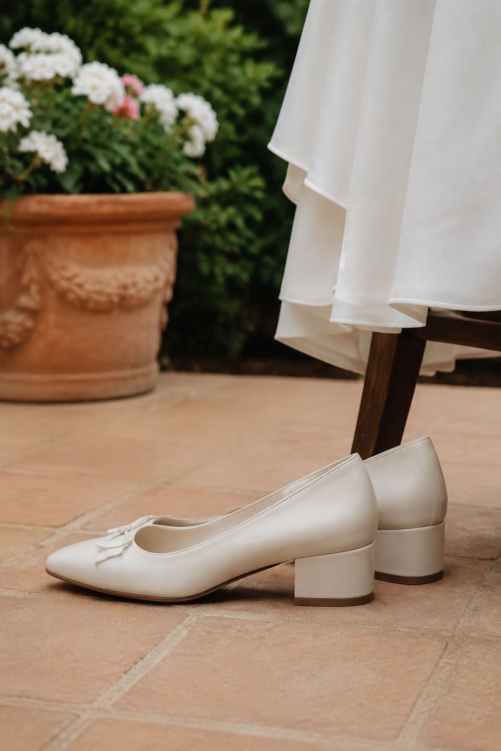 Cream ballet pumps with broad low block heels on courtyard tiles