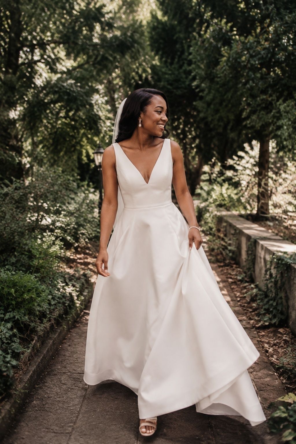 Bride walking on a garden path in a gown with moderate skirt volume