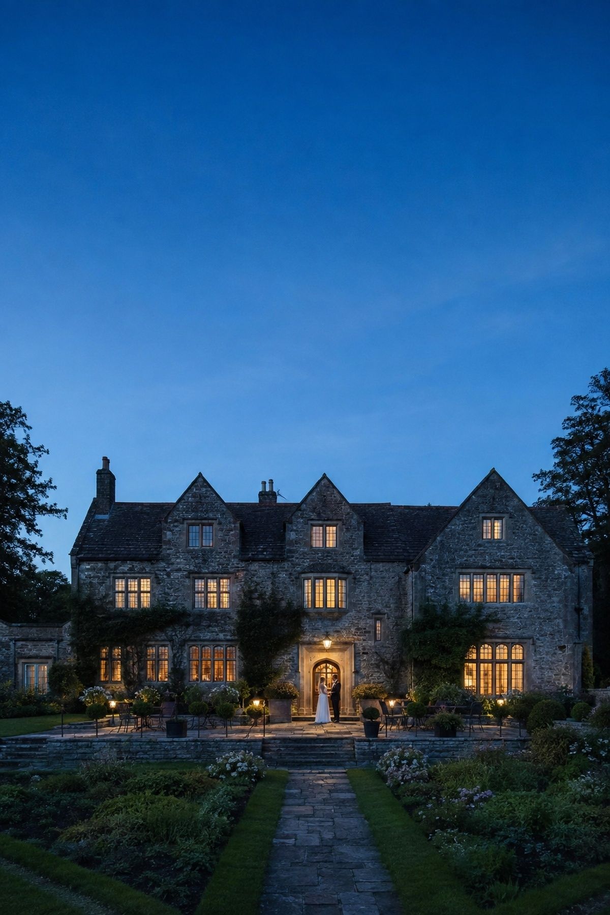 Historic intimate wedding venue glowing under a cobalt blue twilight sky