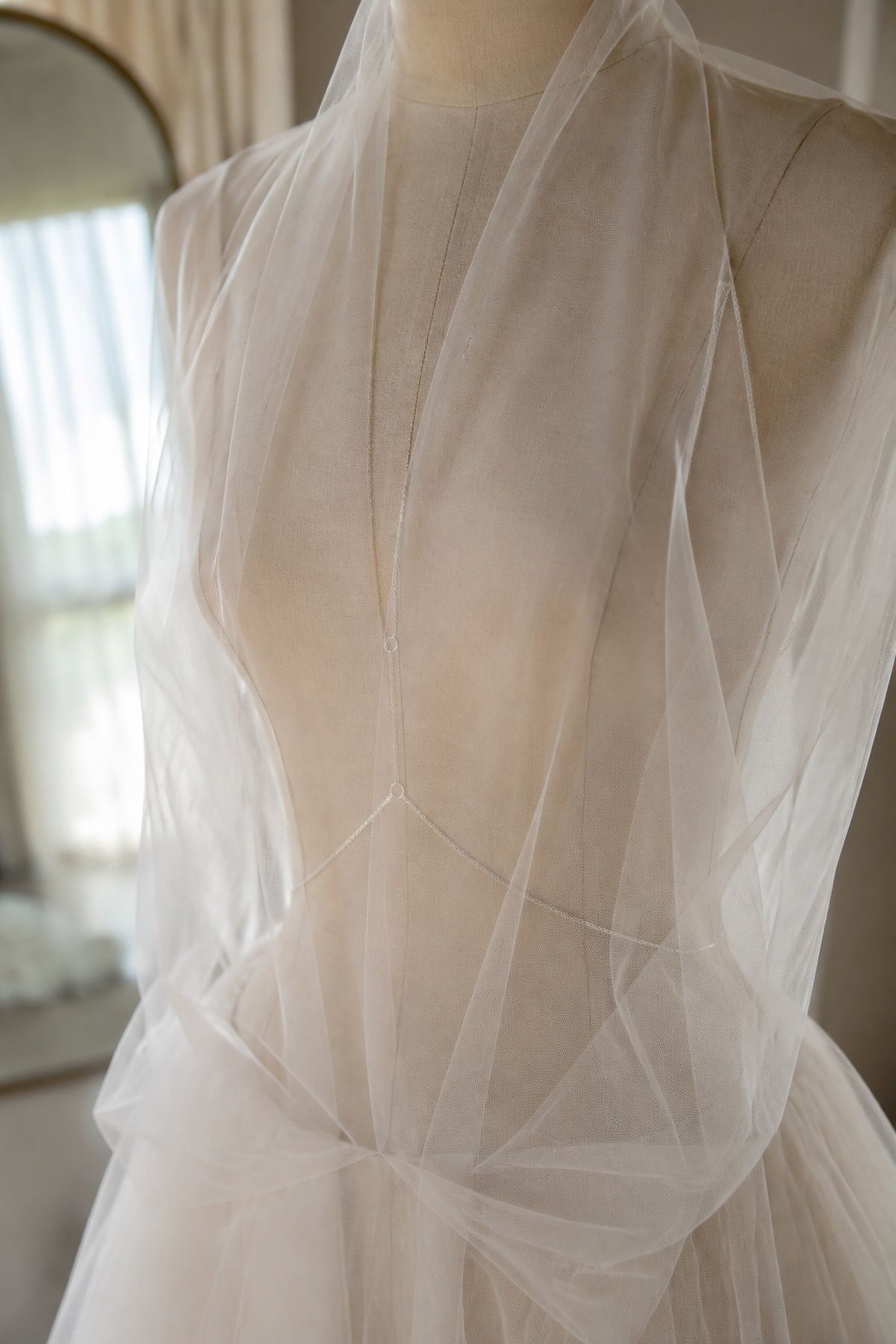 Minimal torso chain under a sheer bridal overlay