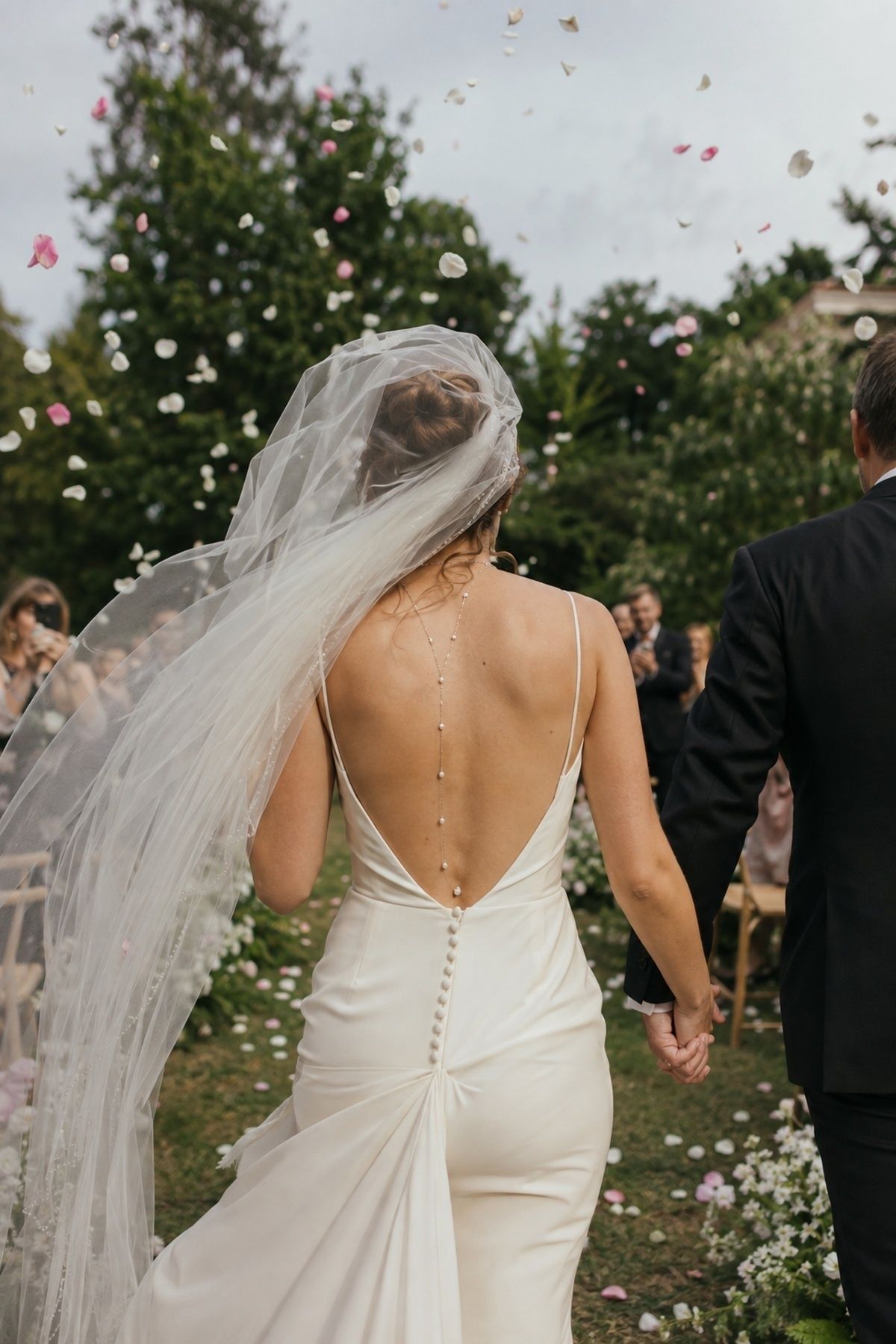 Back necklace catching light in ceremony exit photos