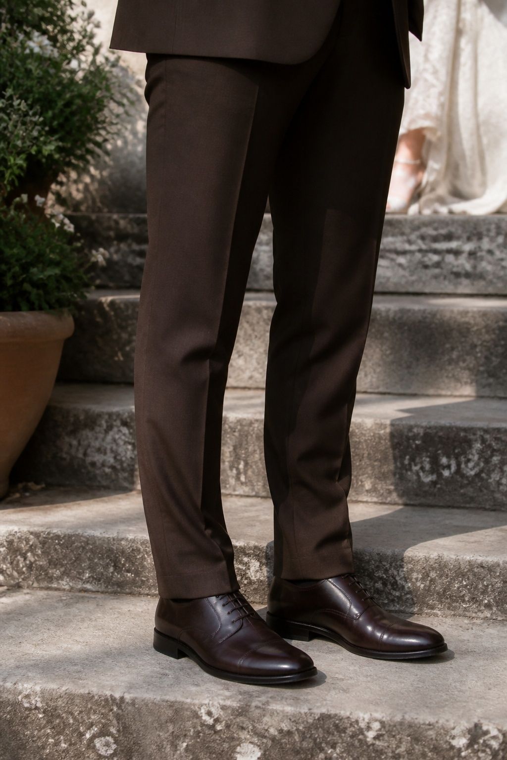 Dark brown Oxford shoes below tailored chocolate suit trousers