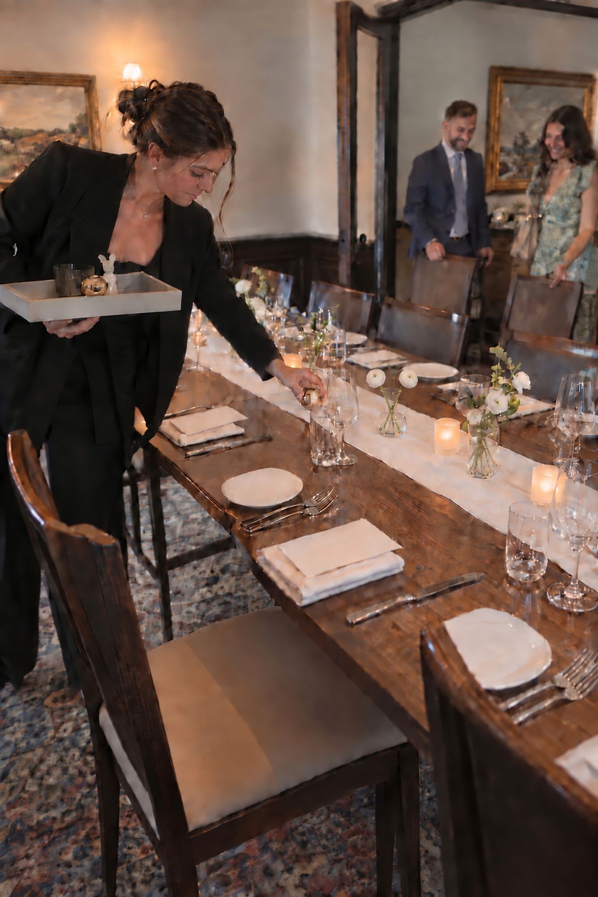 A coordinator edits excess decor from a functional guest table just before dinner.
