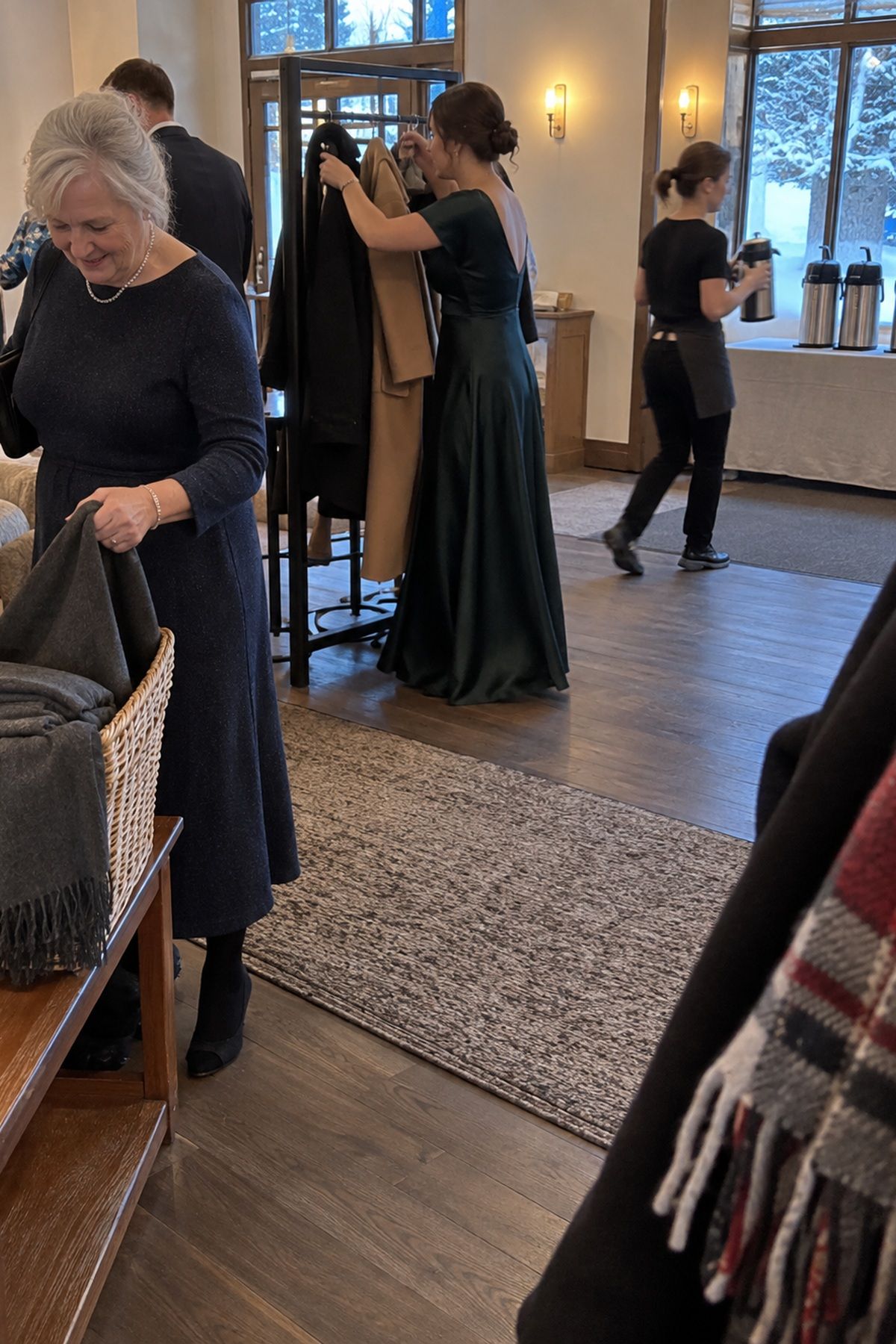 Winter wedding guests use a wrap basket, coat rack, and simple hot-drink station instead of extra decoration.