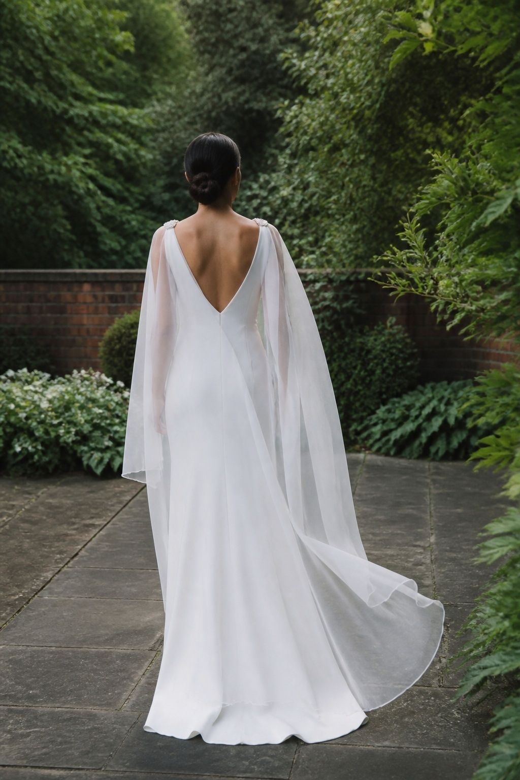 Medium-width tulle cape veil falling in soft wings from both shoulders.