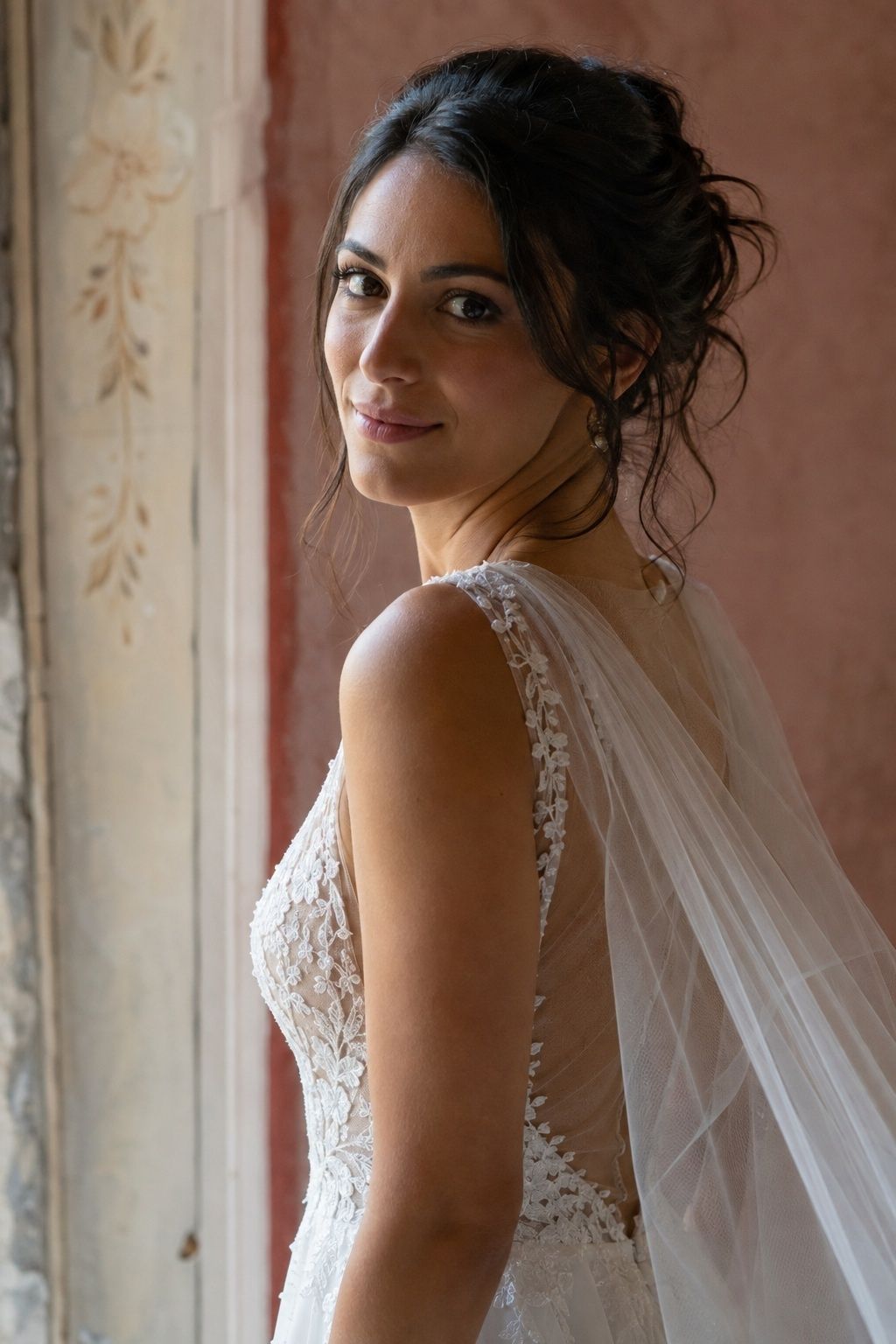 Side bridal portrait showing a sheer shoulder veil moving behind the arm.