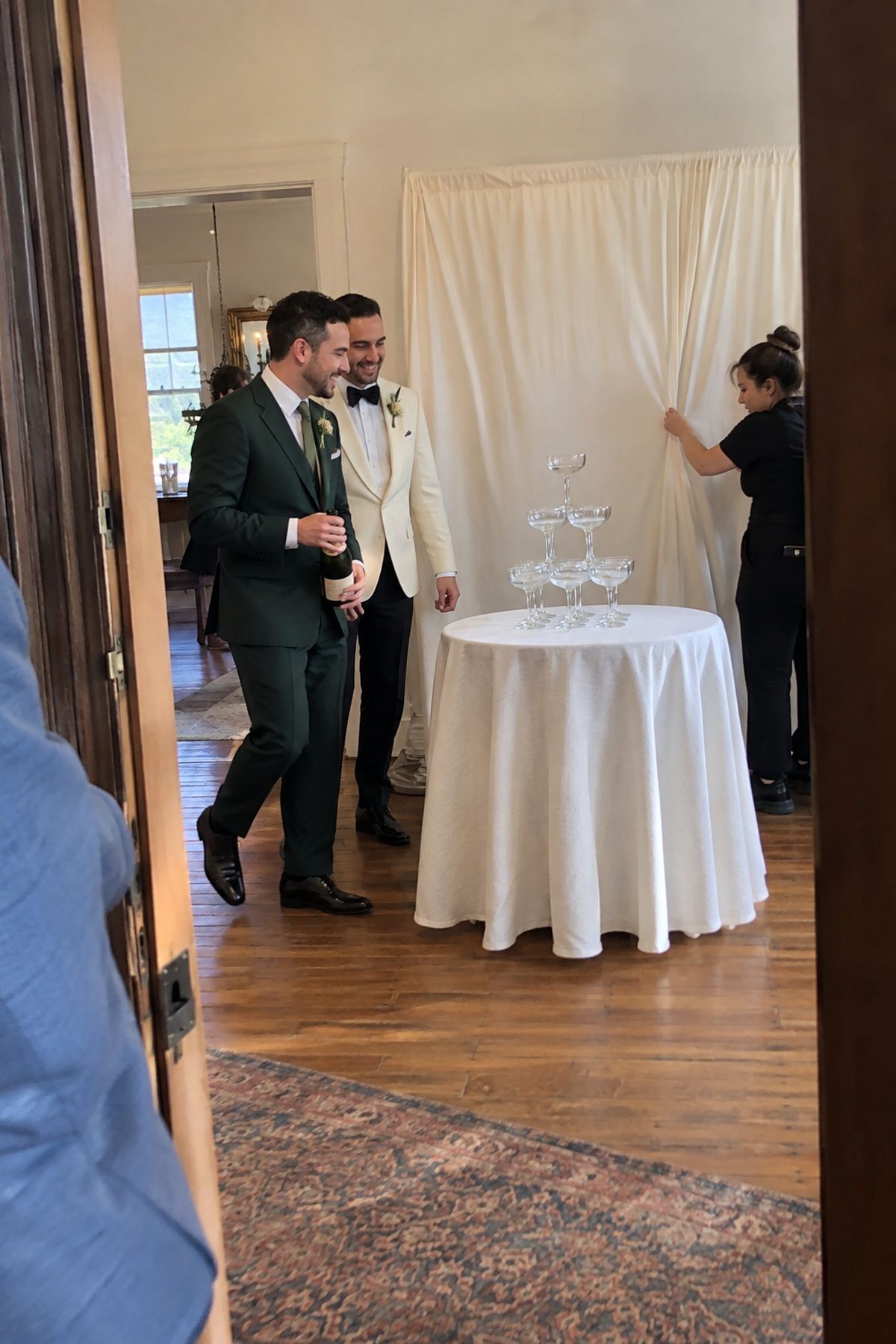 A simple cream drape creates a clean photo backdrop for a champagne tower.