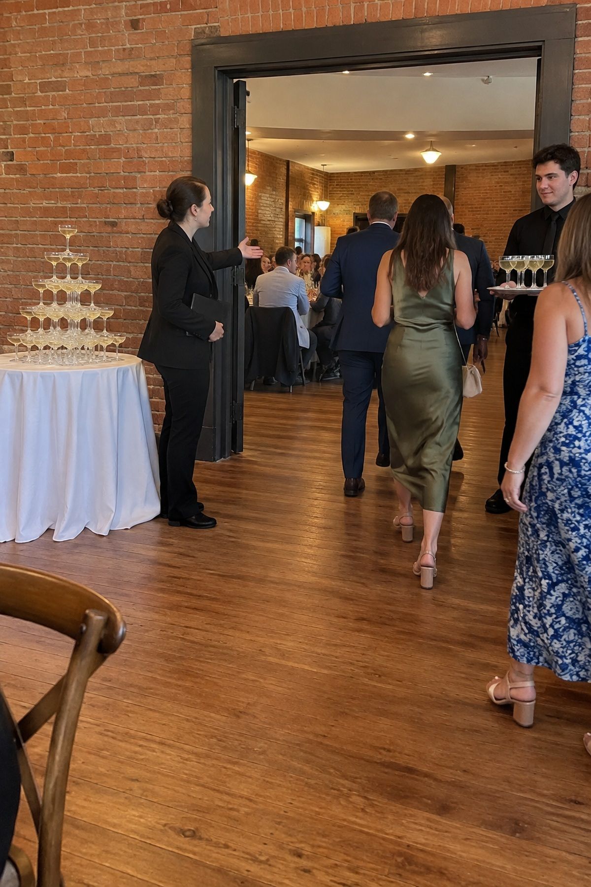 Guests follow a clear open route away from a champagne tower viewing area.