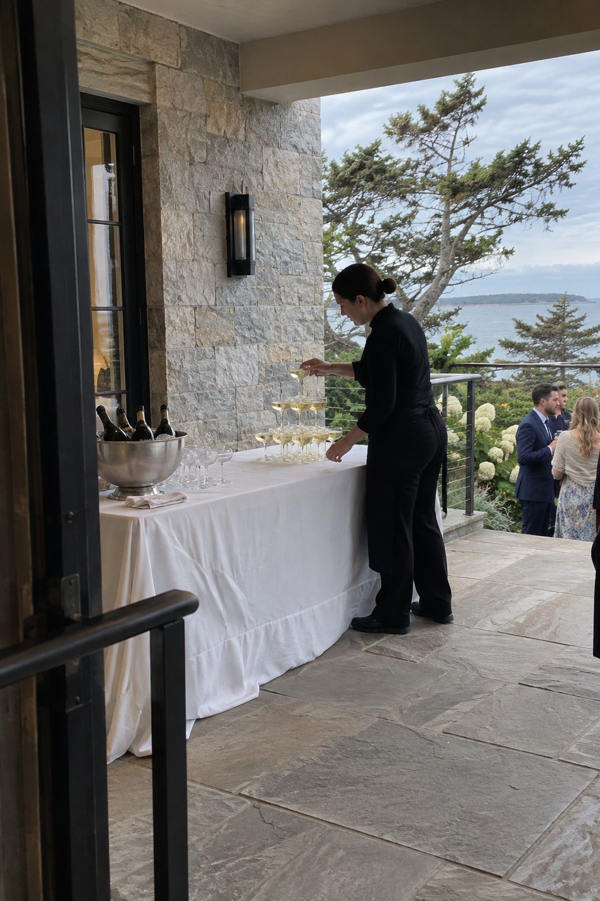 A sheltered level patio setup protects a champagne tower from wind and heat.