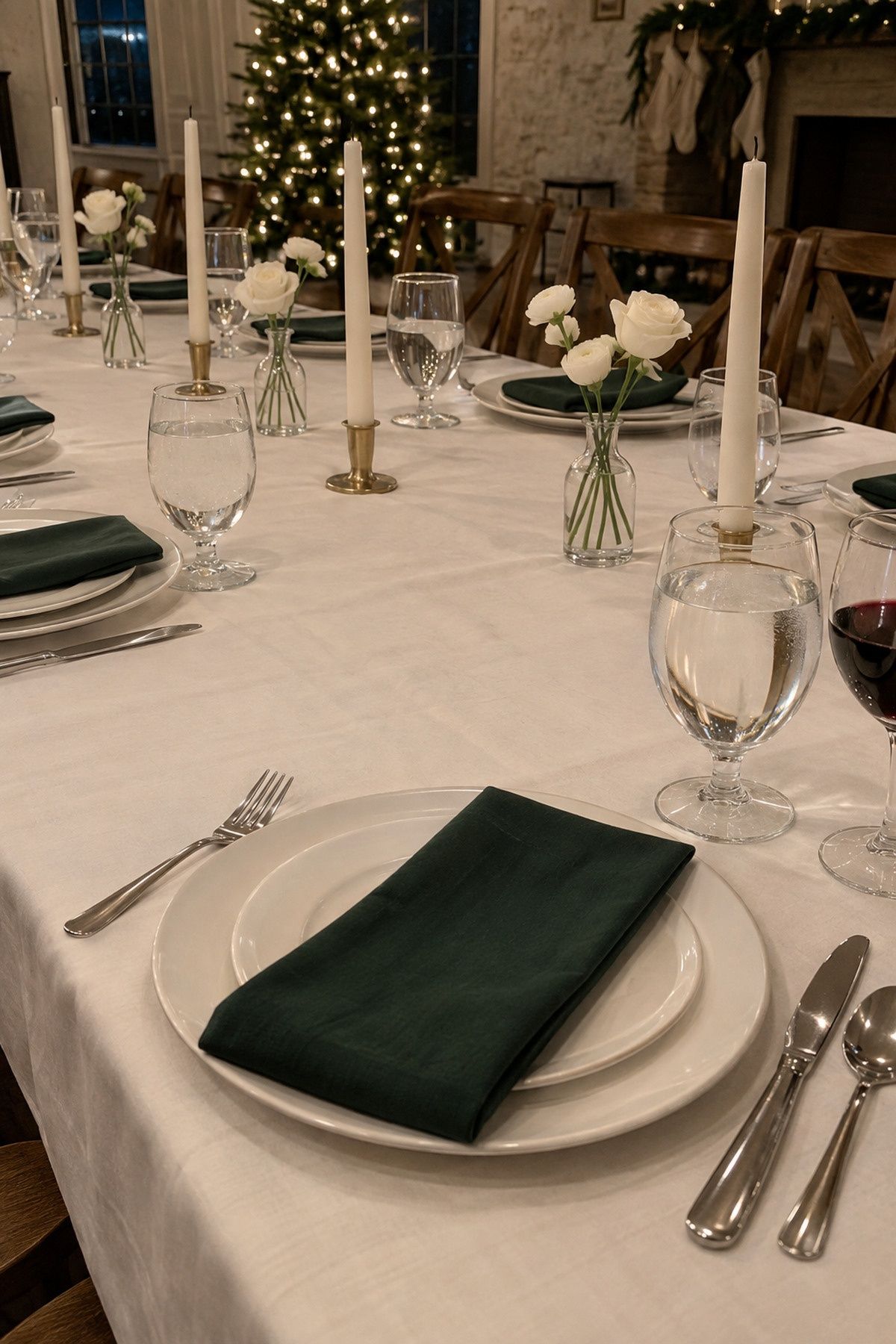 Slim white-flower bud vases spaced between unlit tapers at an intimate Christmas wedding reception