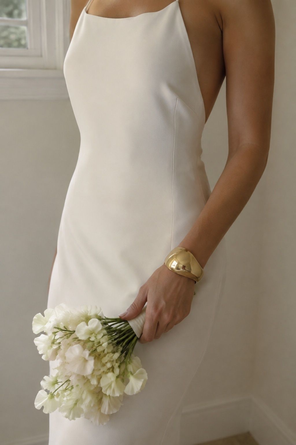 Minimal wedding dress with sculptural wrist jewelry