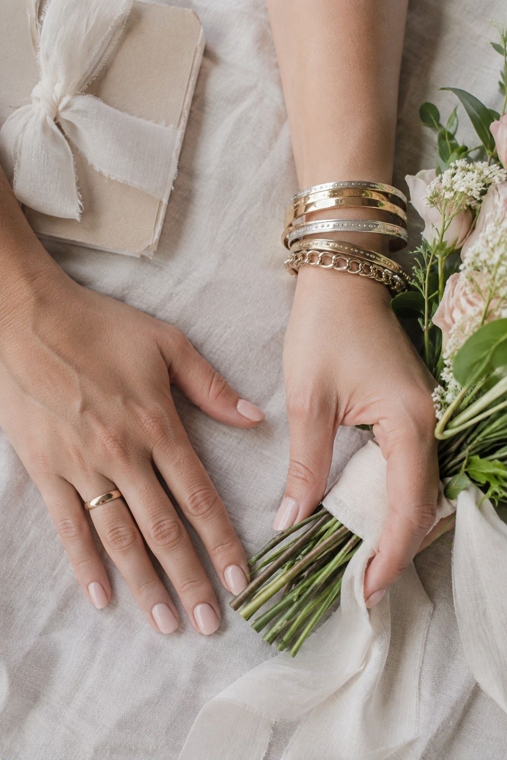 Bare ring hand beside a stacked bangle wrist