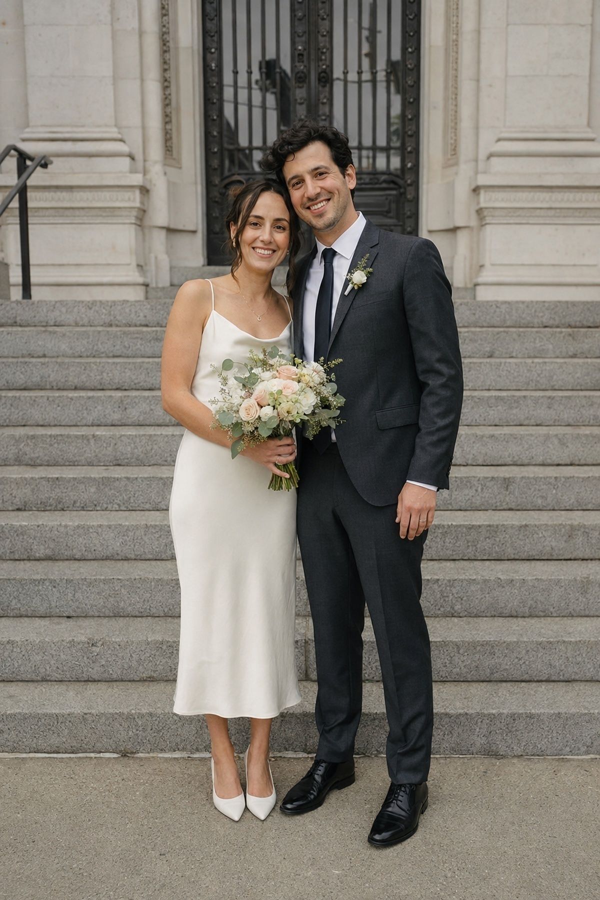 Newlywed couple taking a brief portrait on city hall steps after a civil ceremony