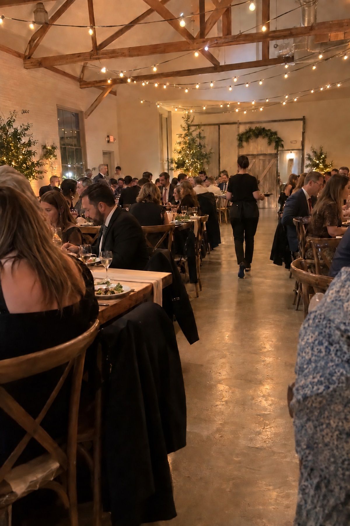 Soft amber string lights glow over an active intimate wedding reception.