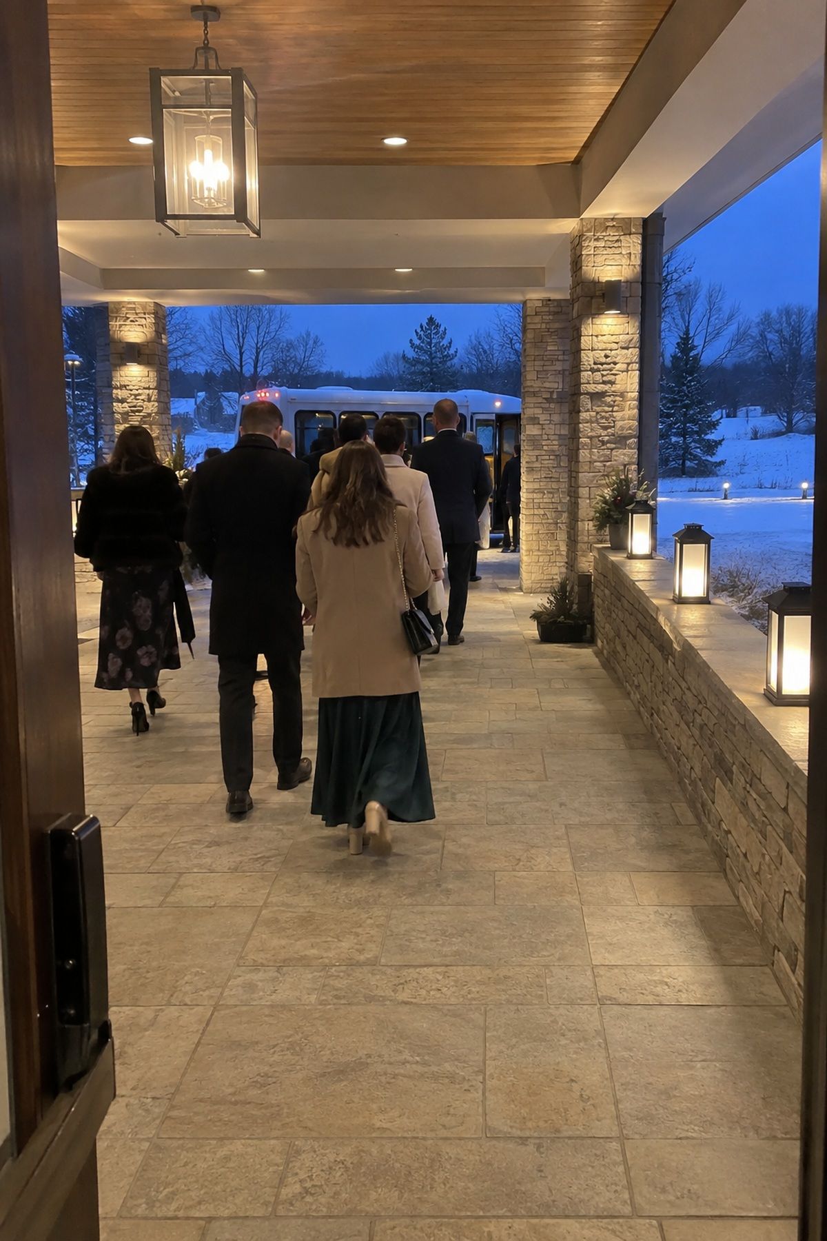 Battery lanterns mark a dry covered path from the winter wedding venue to a waiting shuttle.