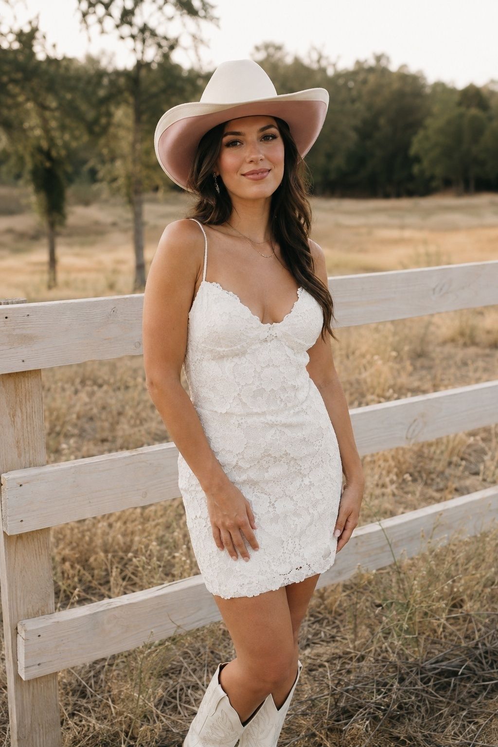 Bride wearing an ivory cowboy hat with dusty rose ribbon under the brim