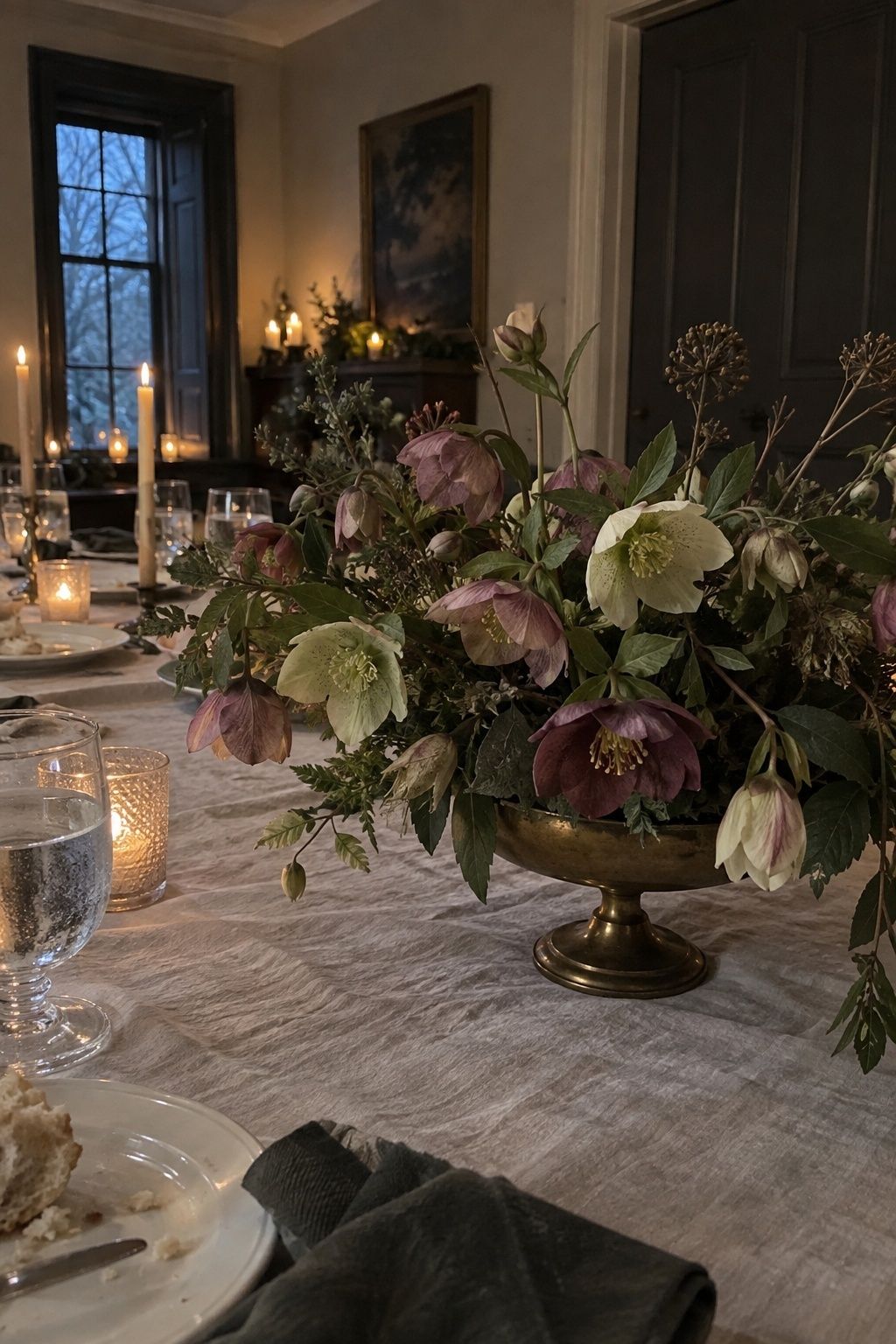 Mauve and pale green hellebores in a low candlelit December wedding centerpiece