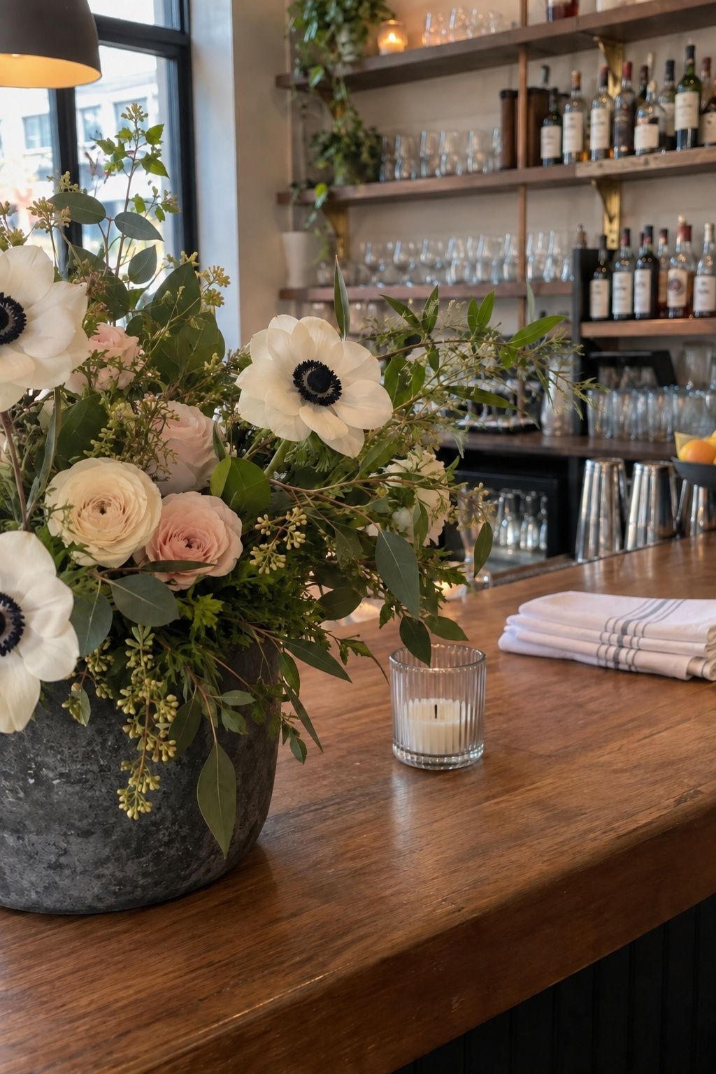 White black-centered anemones in a restrained December wedding bar arrangement