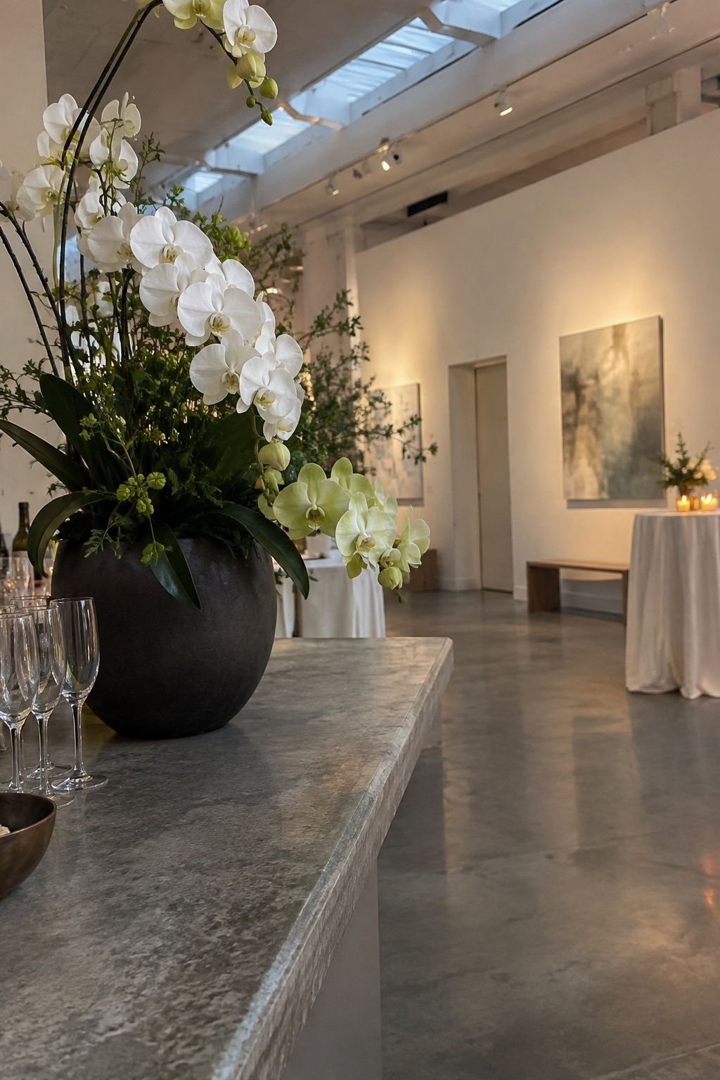 White and pale green orchids in a modern indoor December wedding bar arrangement