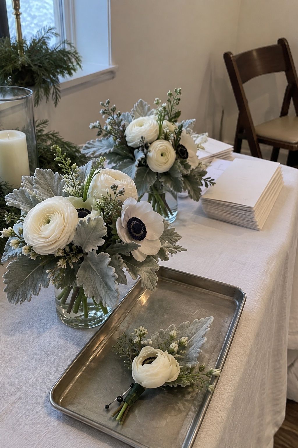 Silvery dusty miller with white ranunculus and anemones on a December chapel prep table