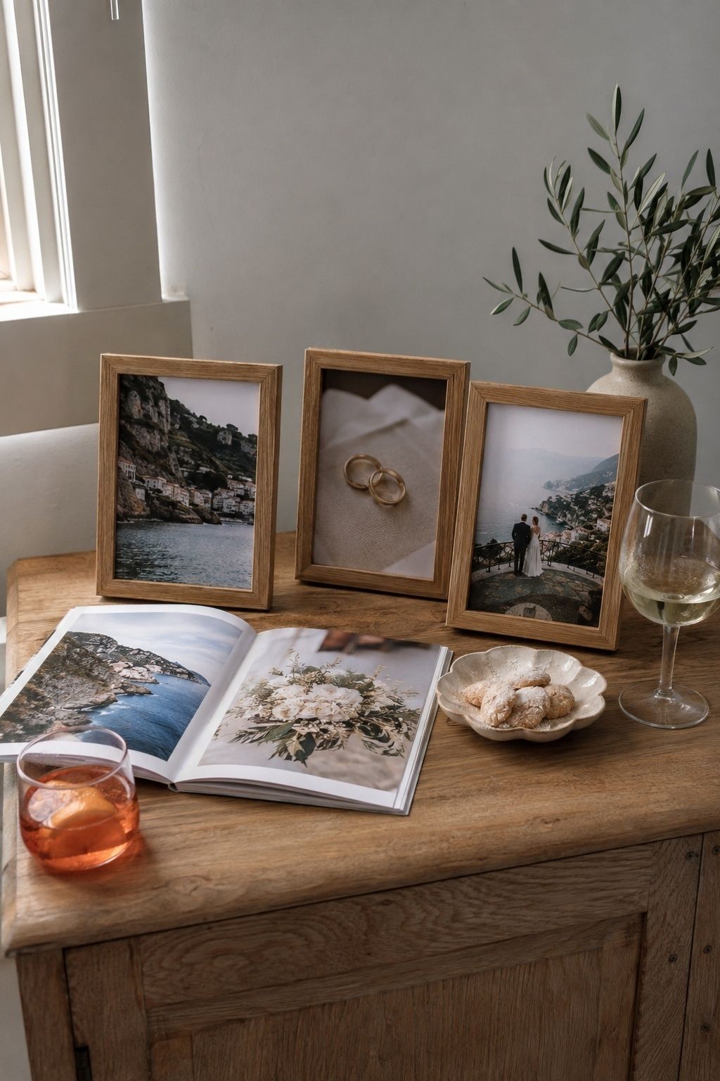 Elopement photo display with framed travel pictures, wedding rings and an album