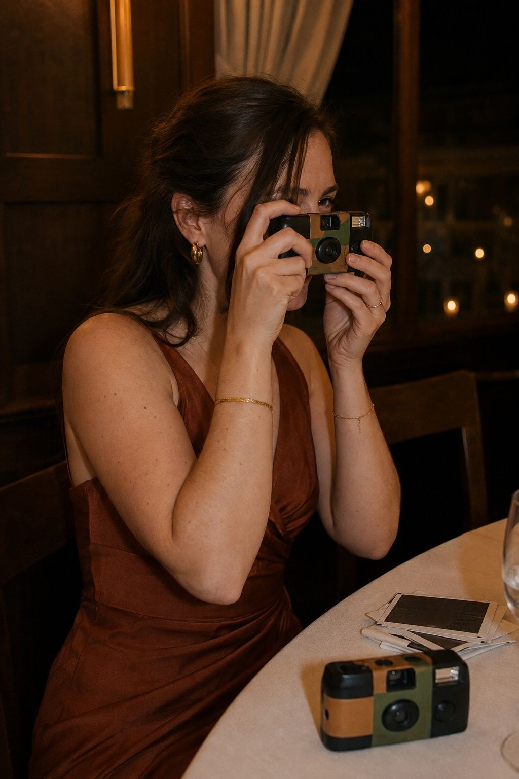Wedding guest laughing as she takes a candid frame with an unbranded disposable camera