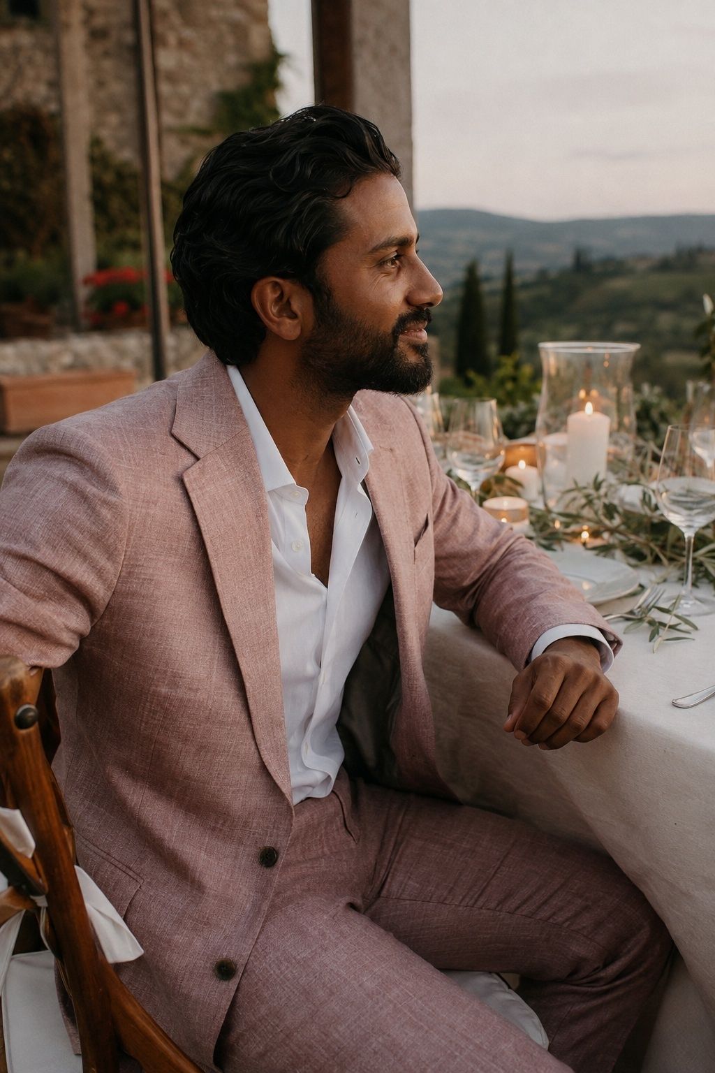 Groom wearing textured dusty rose linen at an intimate terrace dinner.