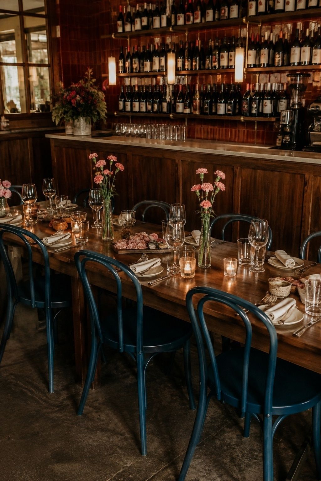 Bistro dinner table with wine, charcuterie and teal chairs