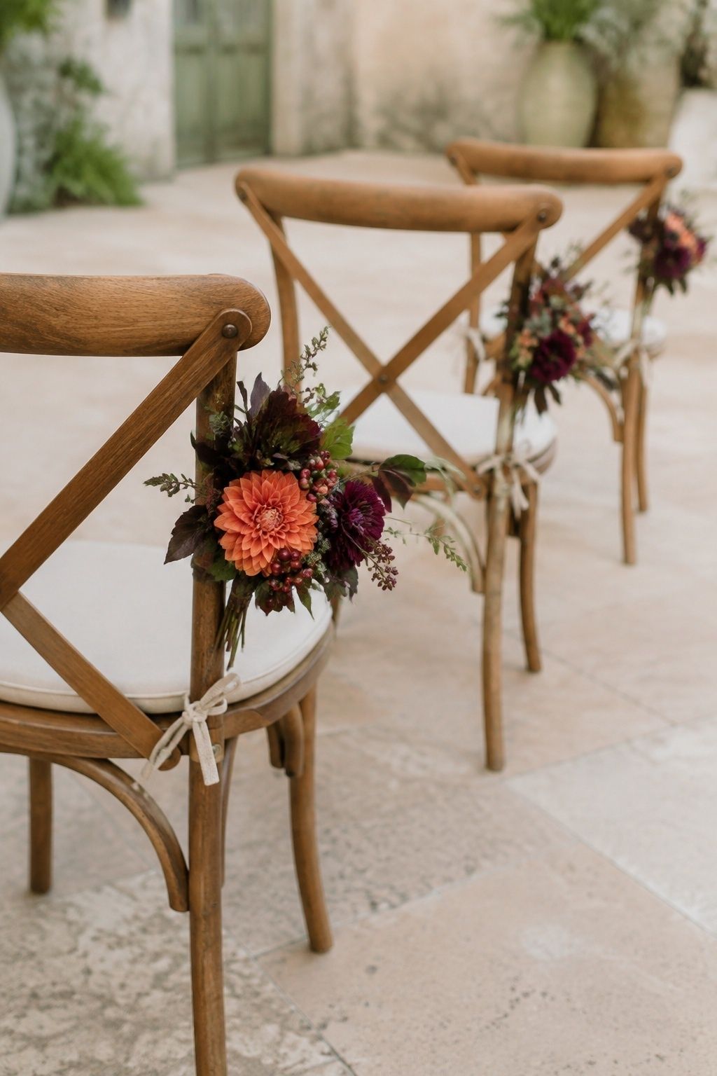 Mini florals in fall colors on the ends of ceremony chairs