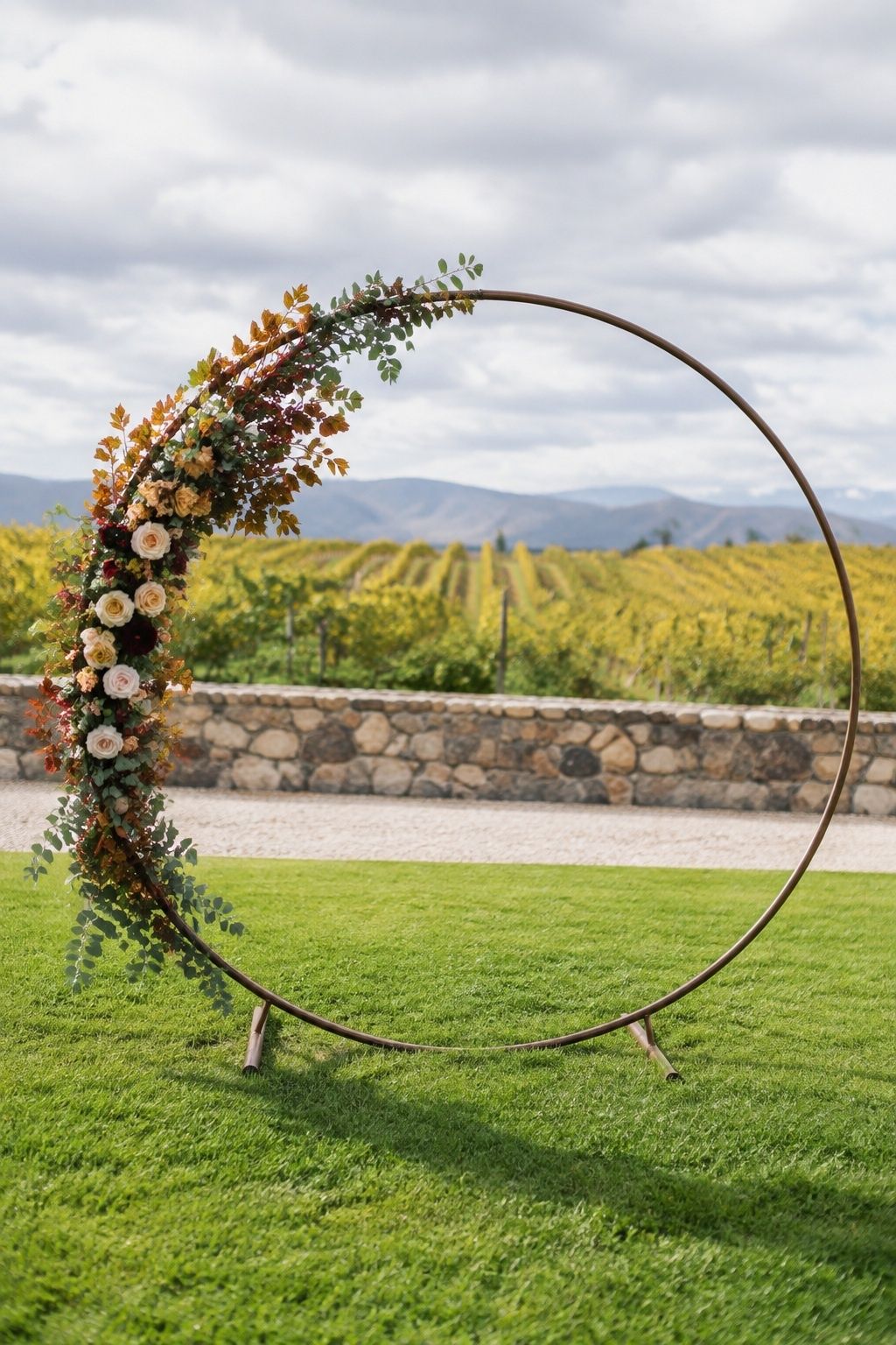 Round ceremony arch dressed in soft autumn foliage