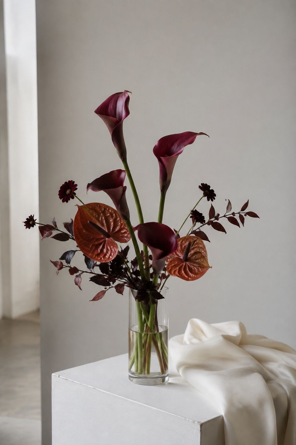 Sculptural aubergine calla lilies and rust anthuriums