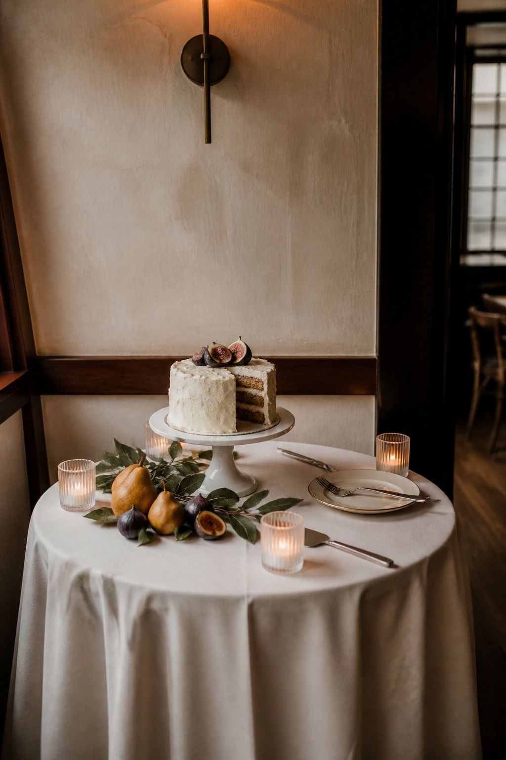 Cake table styled with linen, fruit and candlelight