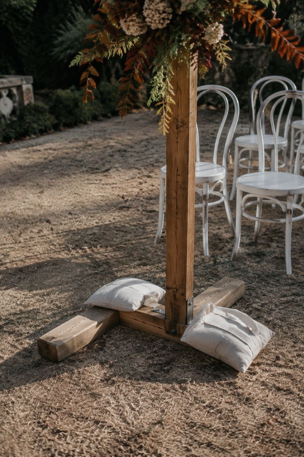 Canvas sandbags weighing down the timber base of an autumn wedding arch