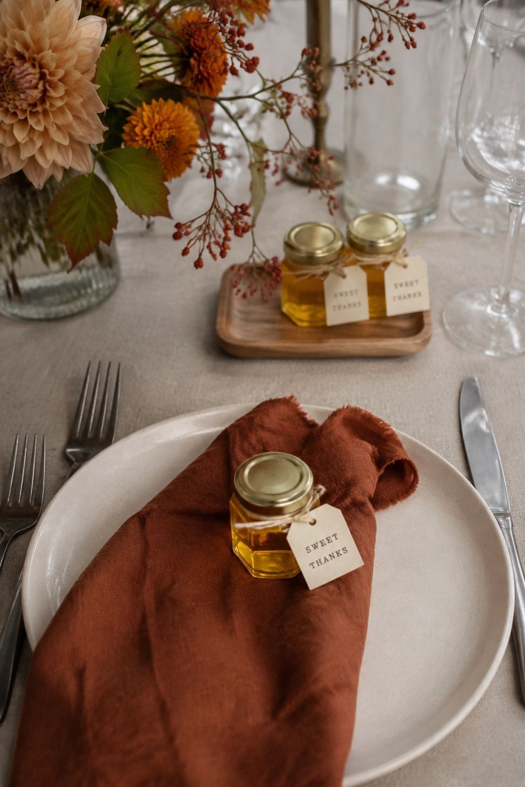Mini honey jar with a Sweet Thanks tag on a rust napkin