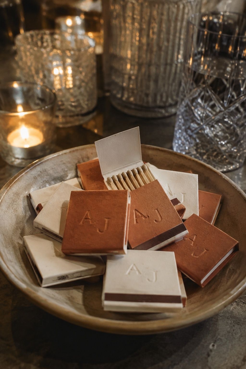 Cream and terracotta initialed matchbooks in a ceramic bowl