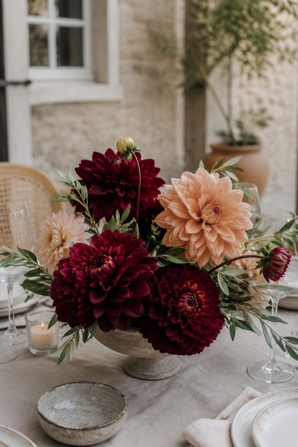 Burgundy and peach dahlias in a low wedding compote