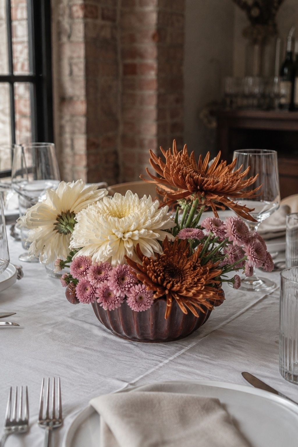 Ivory, bronze and pink chrysanthemums in a low bowl