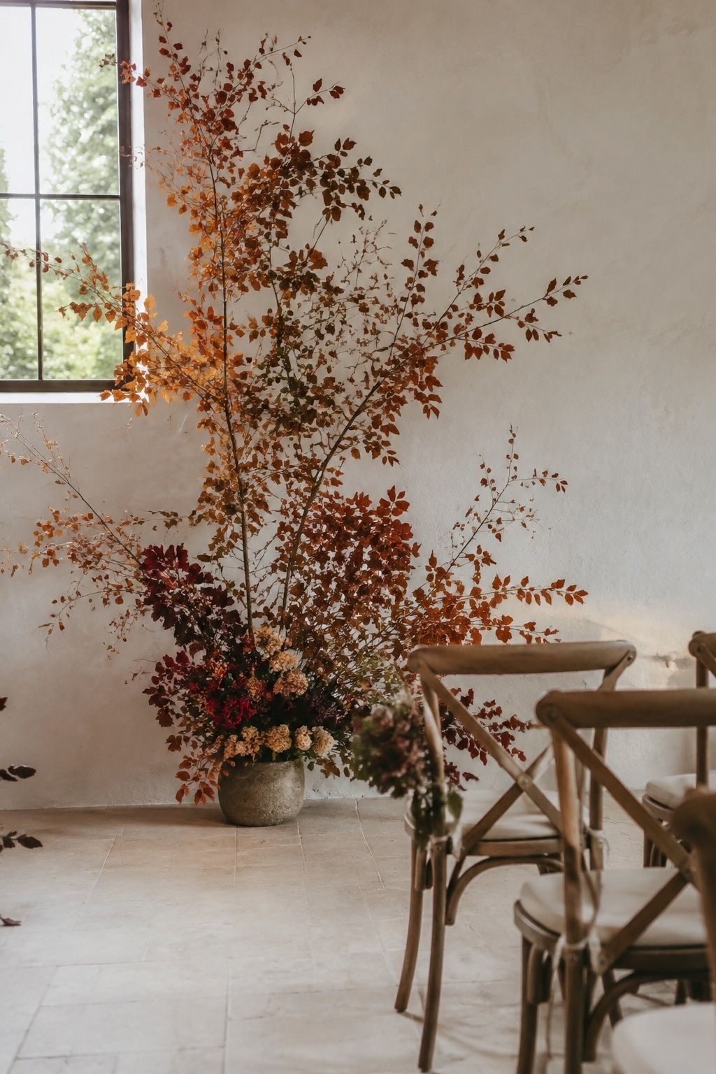 Autumn branches beside an intimate wedding ceremony aisle