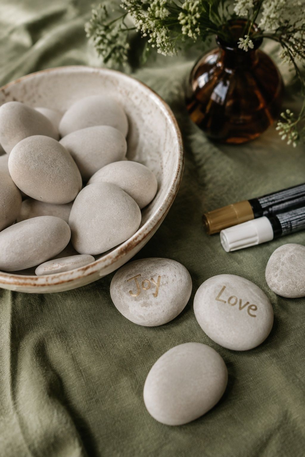 Pale wishing stones marked Joy and Love in a ceramic bowl