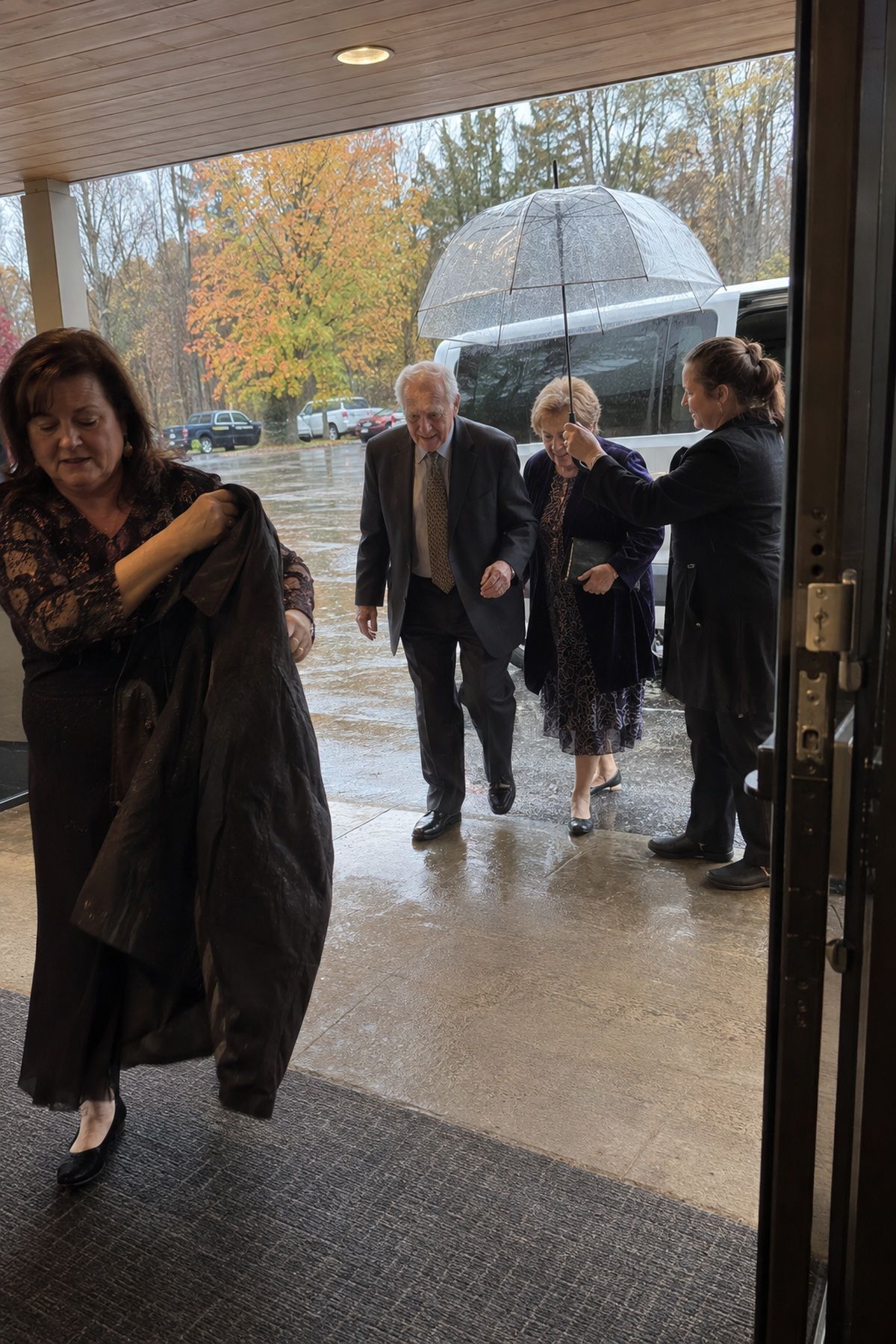 An attendant covers an older couple's short arrival route from a shuttle to a wedding entrance.