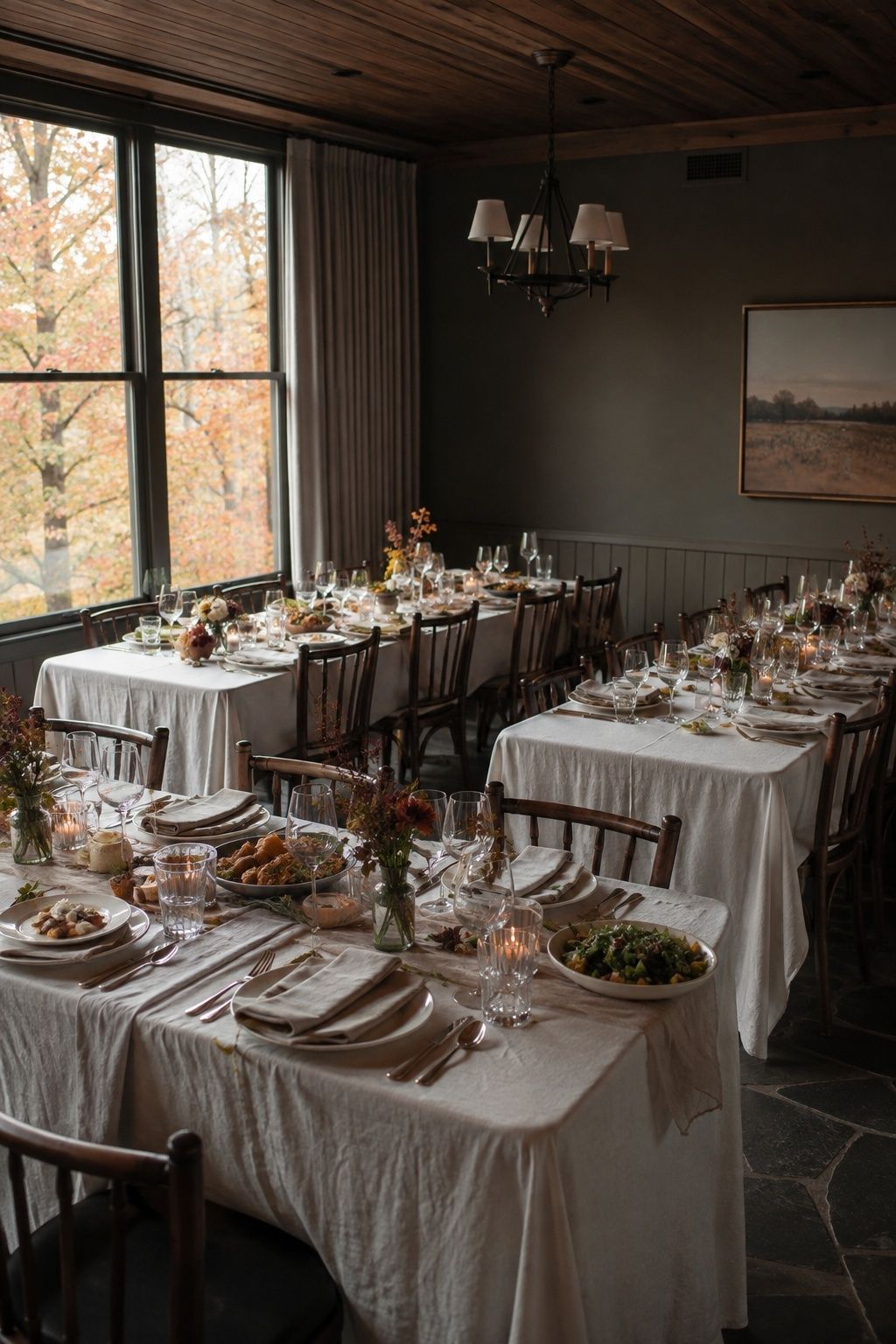 Intimate autumn reception room with close rectangular dinner tables and open service paths