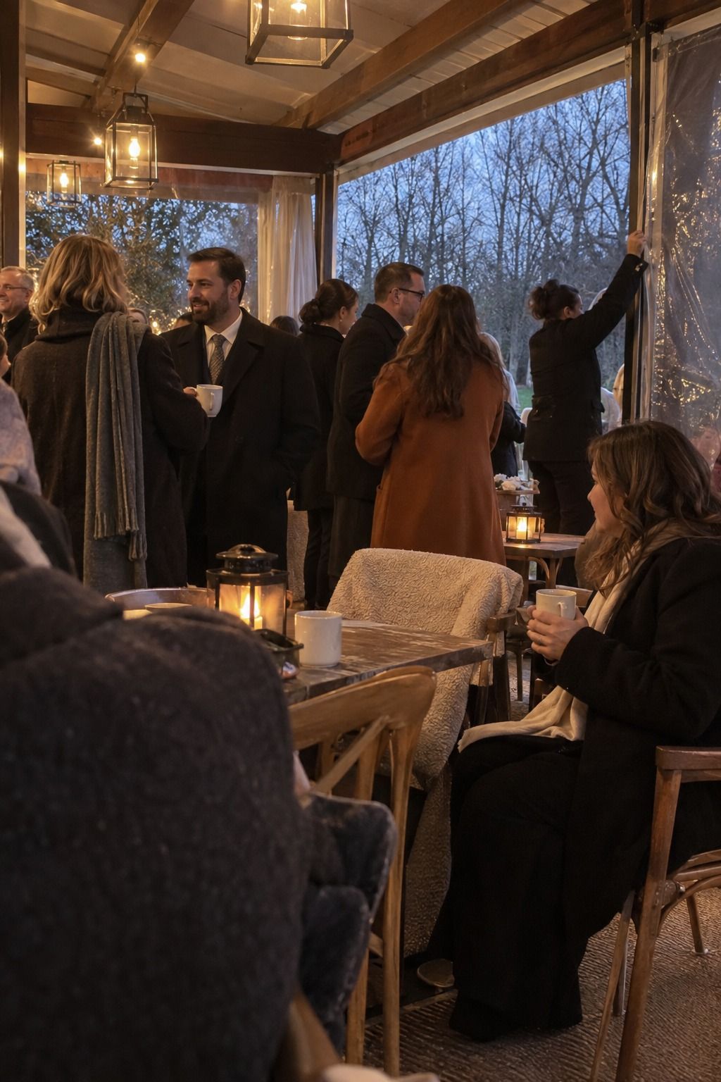Layered guests, blankets, mugs, and a weather curtain prepare the reception for a cold late-autumn evening.