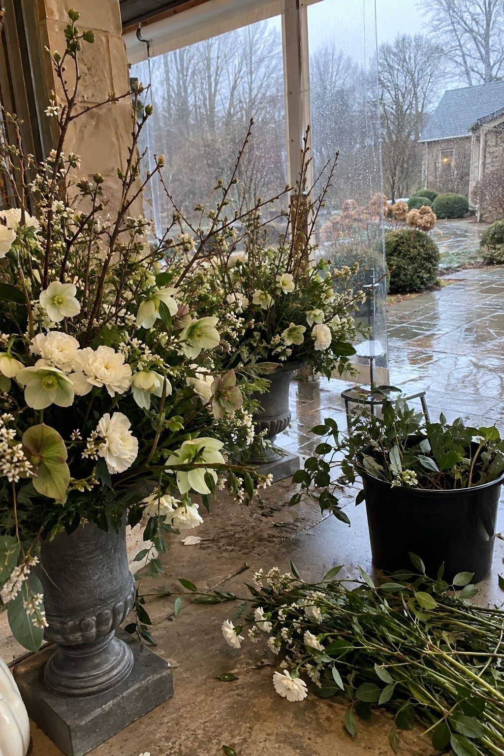 Weighted low February wedding florals protected beneath a covered porch