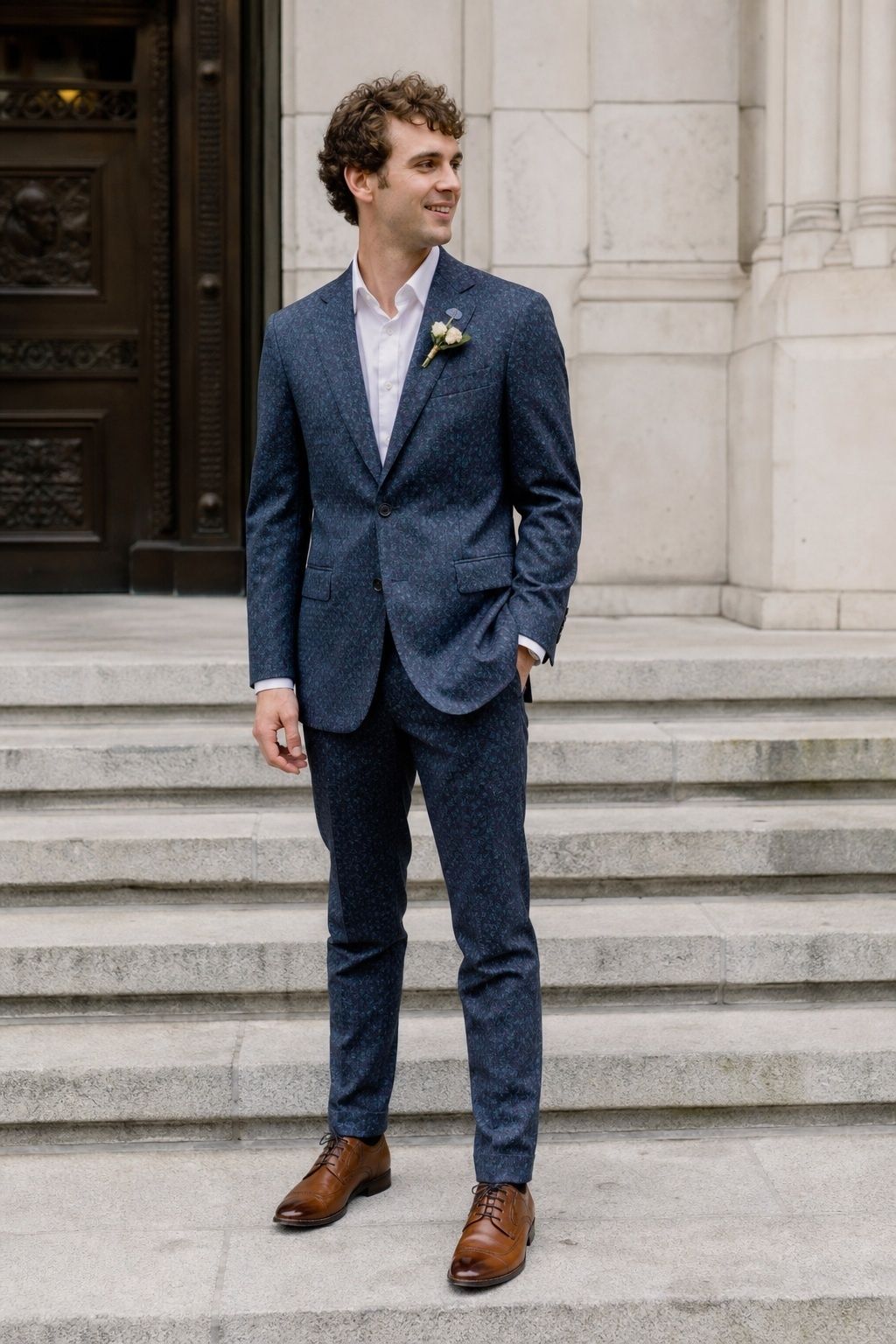 Groom wearing a subtle blue floral suit on city hall steps.