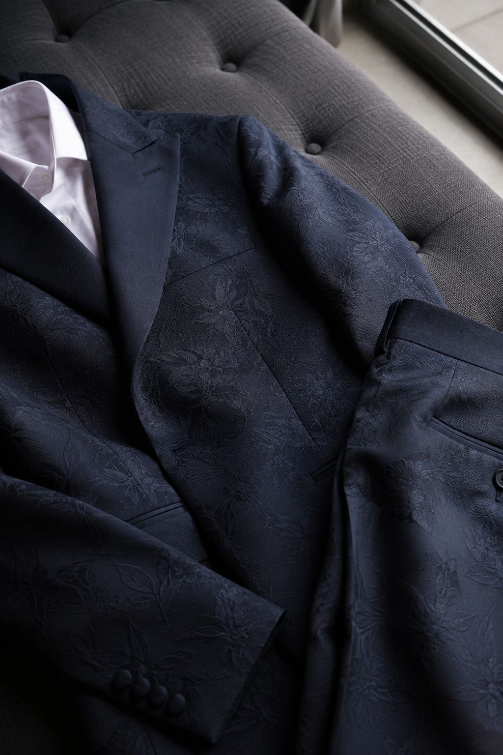 Navy floral jacquard tailoring showing subtle woven texture in window light.