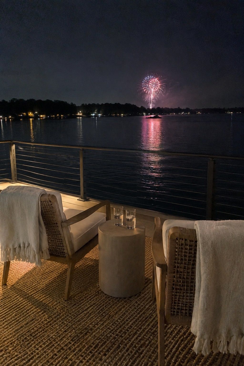 Terrace seating with a distant public fireworks view over water